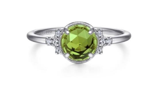 A peridot fashion ring with diamond accents and silver setting