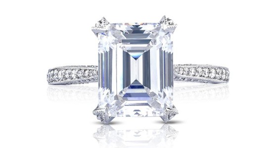 a silver TACORI engagement ring featuring side stones and a prong set emerald cut center stone