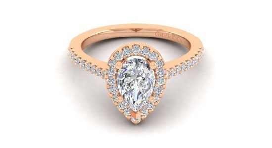 a rose gold halo ring featuring a pear shaped center stone and side stones