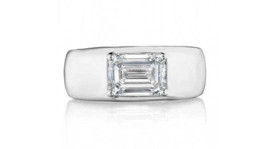 a white gold fashion ring with a wide band and an emerald cut diamond