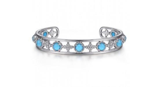 a white gold cuff bracelet set with round cut turquoise