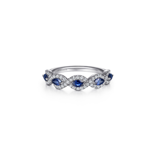 White gold ring featuring alternating marquise blue sapphires and diamond clusters arranged in an infinity loop pattern.