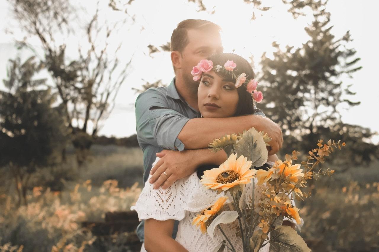 a man wearing a wedding ring embracing a woman