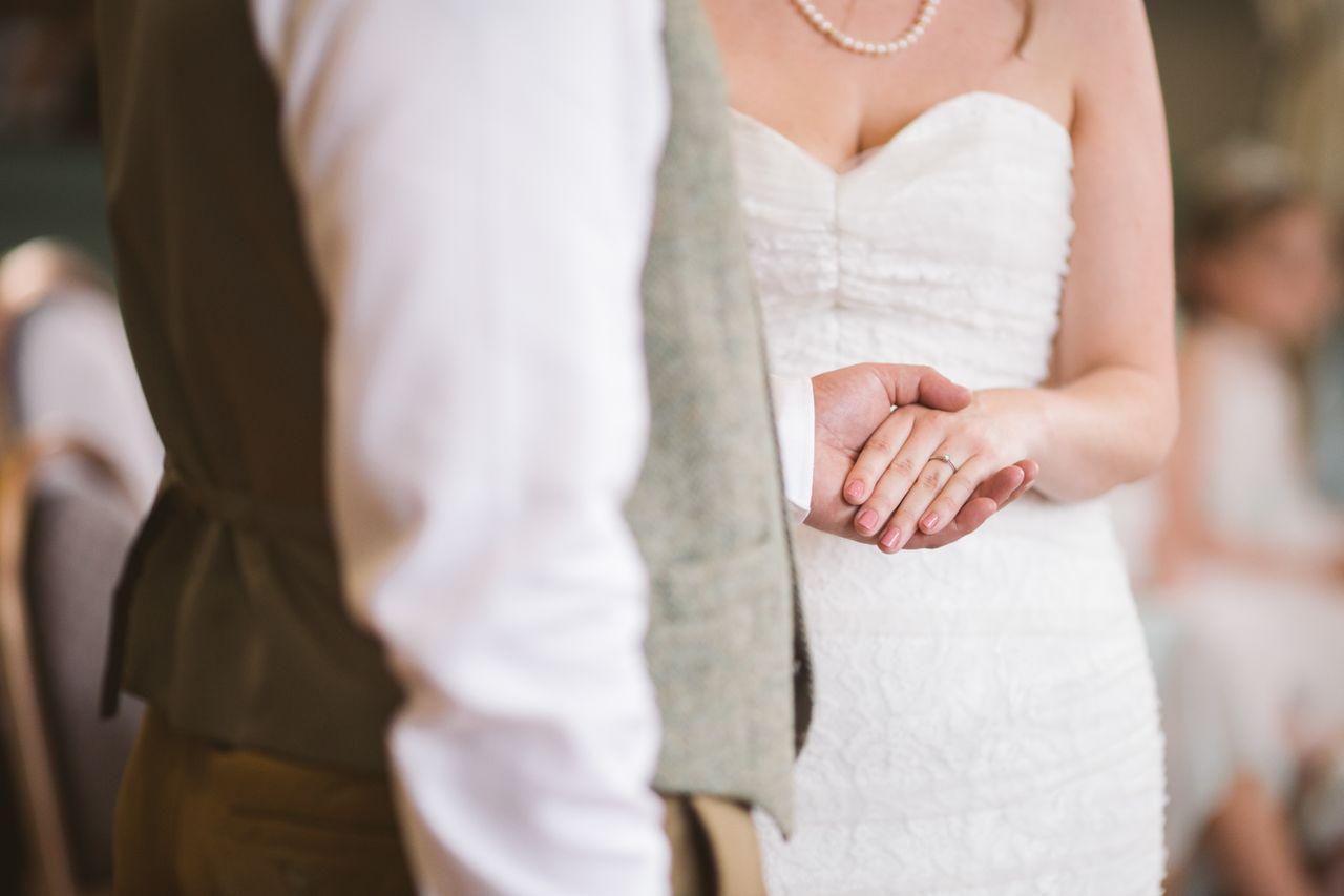 a man holding a woman’s hand wearing a wedding ring